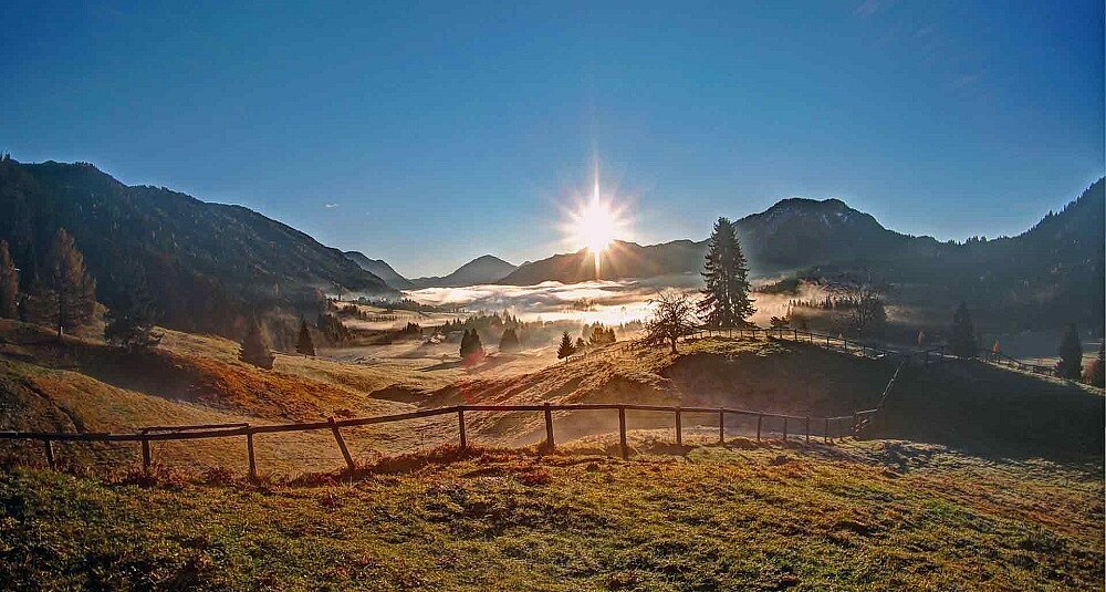 Sommerlicher Sonnenuntergang über dem Weissensee mit Spiegelung im Wasser